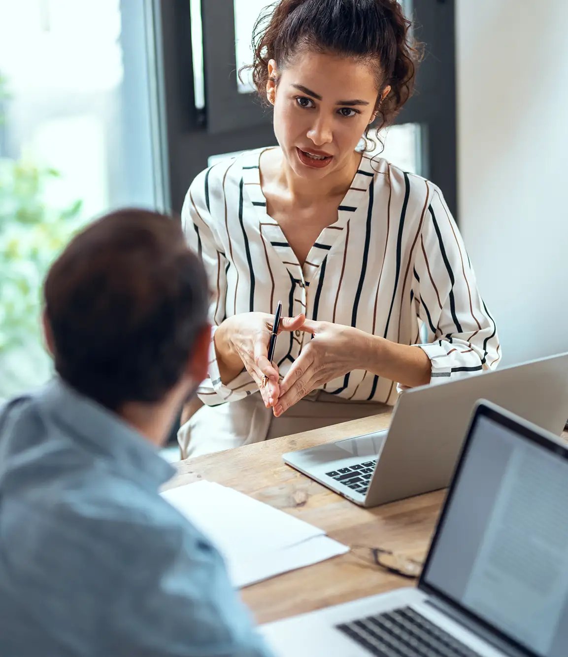 Woman talking with male colleague and working